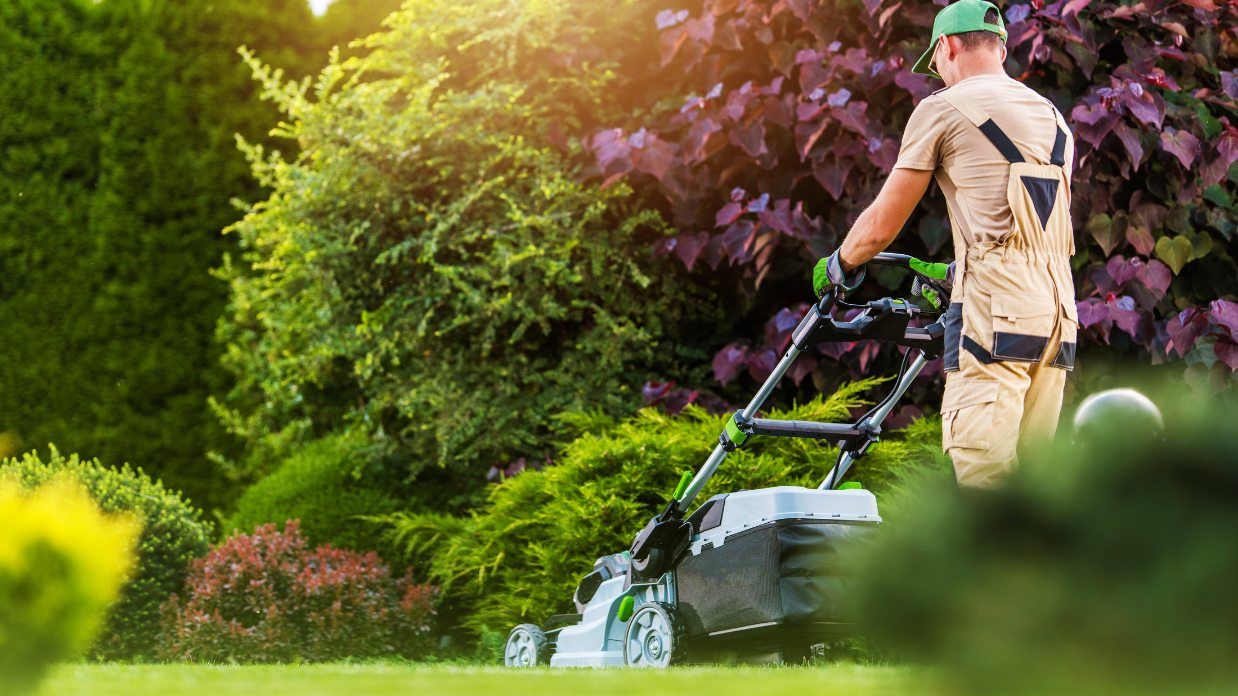 Photo of worker mowing lawn for client 